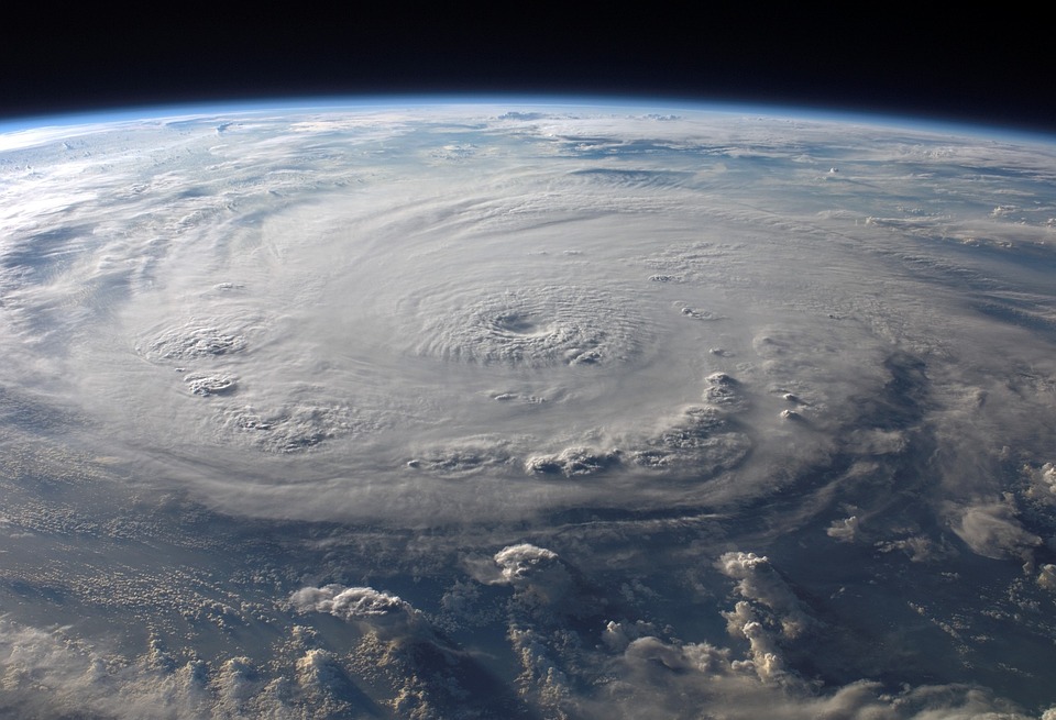 A view of a large hurricane from space, showing the climate-driven storm's vast spiral cloud formation and distinct eye.