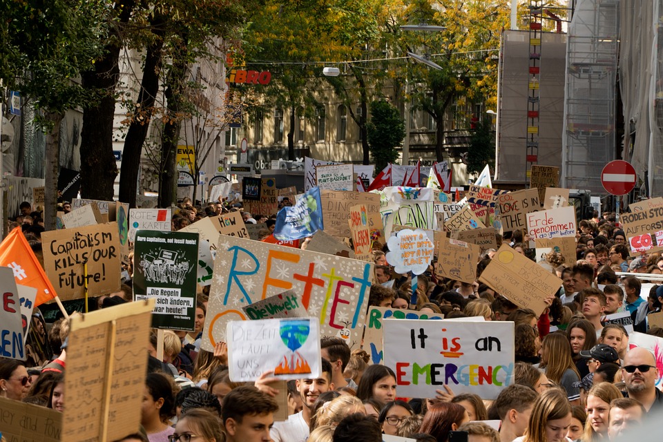 Crowd of protesters carrying signs about climate issues and climate change.