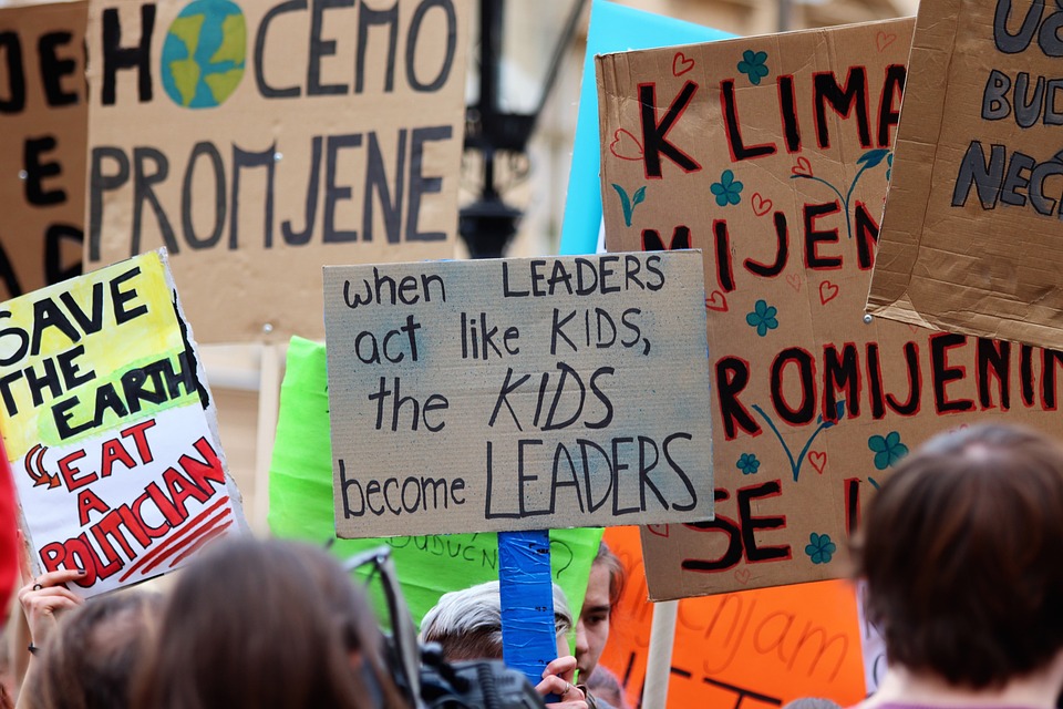 Protesters holding up signs advocating for climate action during a climate demonstration.