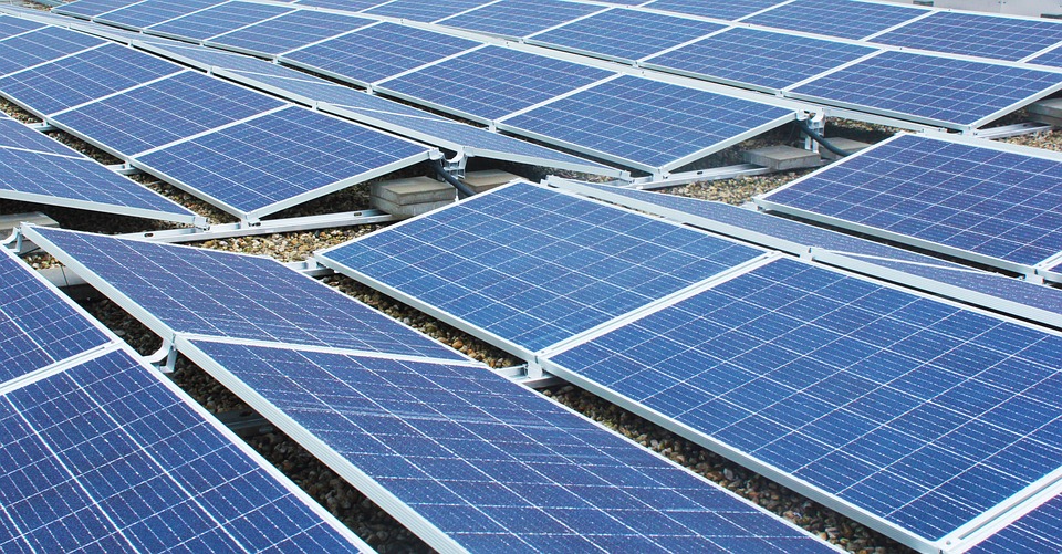 An array of blue solar panels installed on a flat surface to support climate initiatives.
